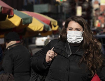 A woman, who declined to give her name, wears a mask in New York out of concern for the coronavirus. Experts say the masks do not necessarily help prevent the spread of the virus. (Mark Lennihan/AP Photo)