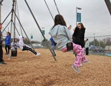 Children gather on the playground at Titus Elementary School, playing and talking to news reporters about the threat of the virus that shut down their school and four others in Central Bucks County. (Emma Lee/WHYY)