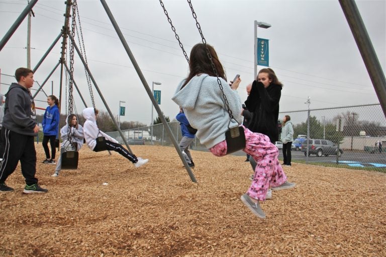 Children gather on the playground at Titus Elementary School, playing and talking to news reporters about the threat of the virus that shut down their school and four others in Central Bucks County. (Emma Lee/WHYY)