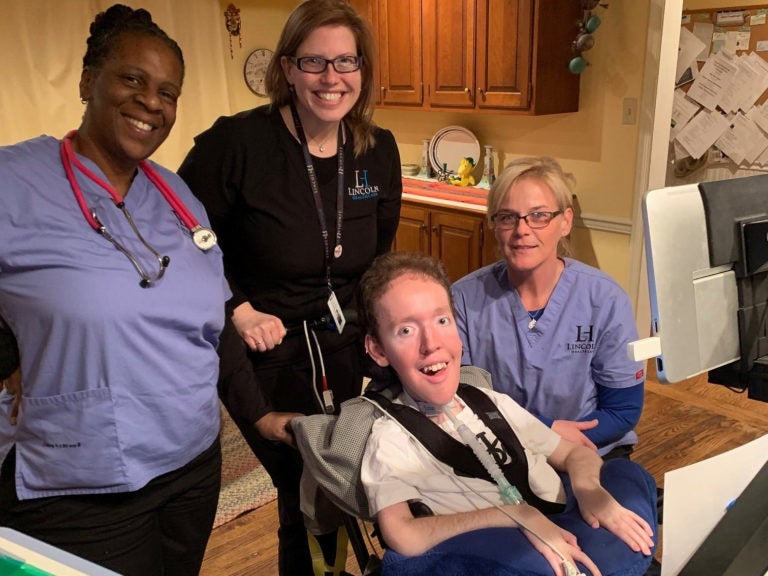 Jack Freedman poses for a photo with licensed practical nurse Kimberly Charleston (left), clinical manager Megan Corbo (middle) and nurse Dawn Pye. Charleston has self-quarantined following a screening process instituted by her employer, Lincoln Healthcare, to send home anyone who lives with someone who may have had contact with a confirmed case of COVID-19. (Courtesy of Al Freedman)