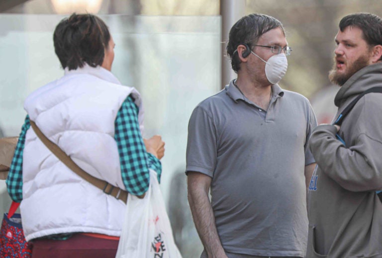 People on Market Street in Wilmington, Del. wearing protective masks on Friday, March 27, 2020. (Saquan Stimpson for WHYY)