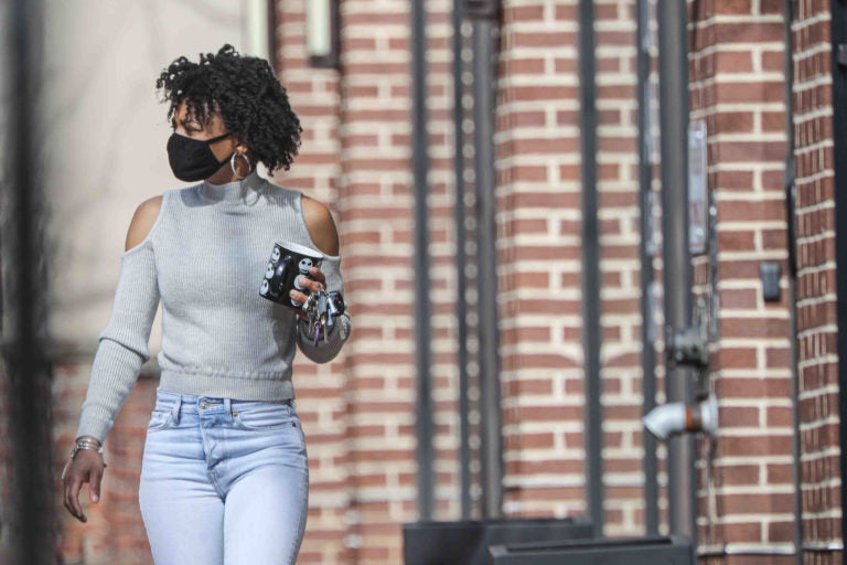 Keona Berry walks down Market Street with a protective mask on her face on Friday, March 27, 2020, in Wilmington, Del. (Saquan Stimpson for WHYY)