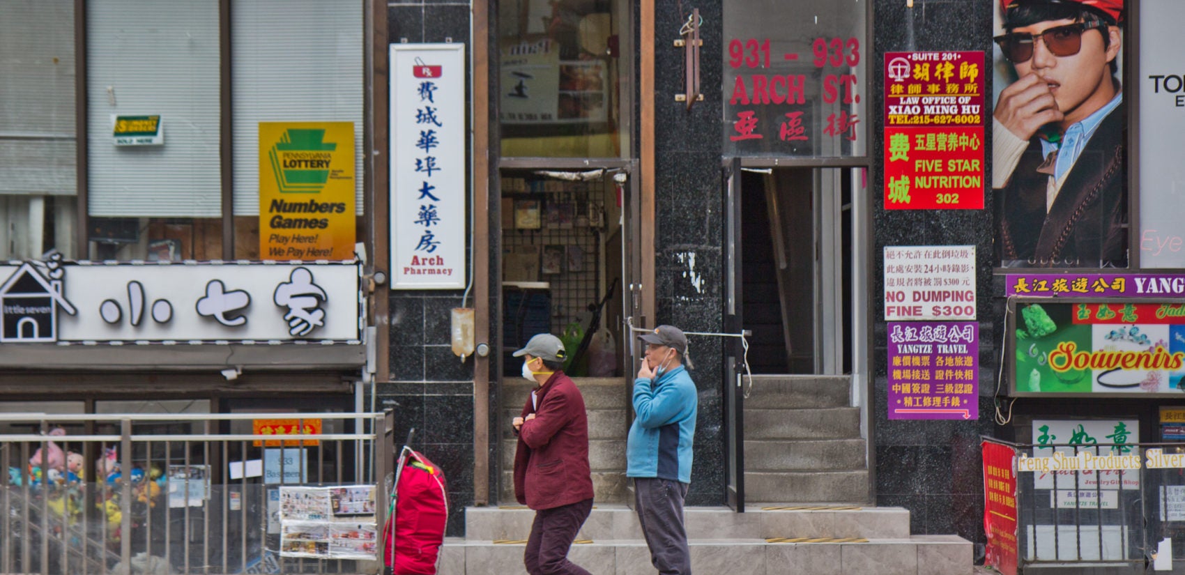 A man wears a surgical mask on Market Street in Philadelphia. (Kimberly Paynter/WHYY)