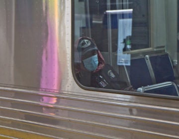 A SEPTA rider dons a surgical mask. (Kimberly Paynter/WHYY)