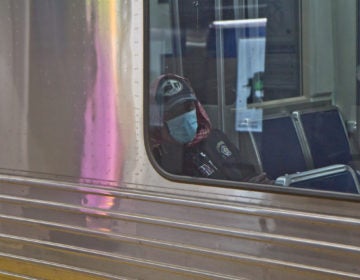A subway rider in Philadelphia dons a surgical mask. (Kimberly Paynter/WHYY)