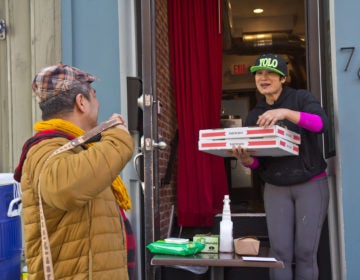 Kalaya owner Nok Suntaranon (right) hands out donated pizza to community members in need. (Kimberly Paynter/WHYY)