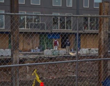 Construction workers on the job at 19th and Reed streets in South Philadelphia in March 2020. (Kimberly Paynter/WHYY)