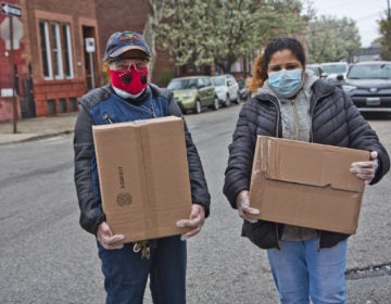 Noelia Ramírez and her daughter Carmen Arroyo, a factory worker, picked up boxes of free food during the coronavirus shutdowns that have students out of schools and workers unemployed. (Kimberly Paynter/WHYY)