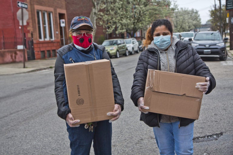 Noelia Ramírez and her daughter Carmen Arroyo, a factory worker, picked up boxes of free food during the coronavirus shutdowns that have students out of schools and workers unemployed. (Kimberly Paynter/WHYY)