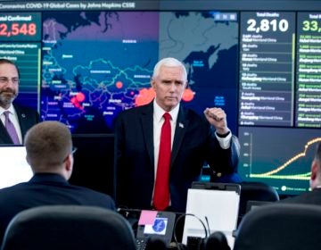 A monitor displaying a map of Asia and a tally of total coronavirus cases, deaths, and recovered, is visible behind Vice President Mike Pence, center, and Health and Human Services Secretary Alex Azar, left, as they tour the Secretary's Operations Center following a coronavirus task force meeting at the Department of Health and Human Services, Thursday, Feb. 27, 2020, in Washington. (AP Photo/Andrew Harnik)