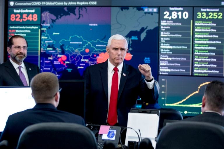 A monitor displaying a map of Asia and a tally of total coronavirus cases, deaths, and recovered, is visible behind Vice President Mike Pence, center, and Health and Human Services Secretary Alex Azar, left, as they tour the Secretary's Operations Center following a coronavirus task force meeting at the Department of Health and Human Services, Thursday, Feb. 27, 2020, in Washington. (AP Photo/Andrew Harnik)