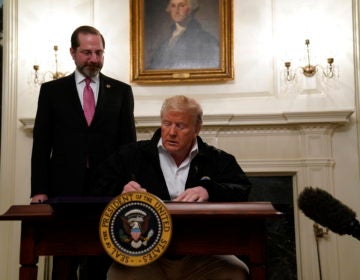 President Donald Trump signs an $8.3 billion bill to fight the coronavirus outbreak in the U.S., Friday, March 6, 2020 at the White House in Washington, as Department of Health and Human Services Secretary Alex Azar, looks on. The legislation provides federal public health agencies with money for vaccines, tests and potential treatments and helps state and local governments prepare and respond to the threat. The rapid spread of the virus has rocked financial markets, interrupted travel and threatens to affect everyday life in the United States. (AP Photo/Evan Vucci)