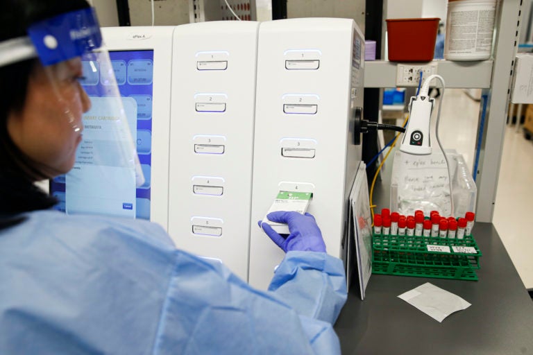 A laboratory technician prepares COVID-19 patient samples for semi-automatic testing at Northwell Health Labs, in Lake Success, N.Y. (John Minchillo/AP Photo)