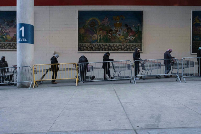 New Jersey joined with New York and Connecticut to close bars, restaurants and movie theaters starting Monday night. Here, customers wait in line at a store in New York. (Yuki Iwamura/AP Photo)