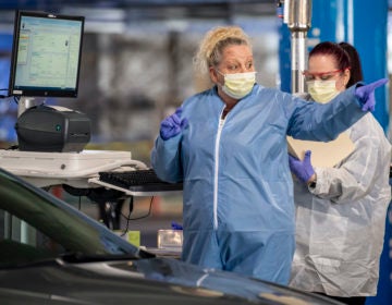 Clinical staff workers conduct a drive-through COVID-19 test Wednesday, March 18, 2020, at Allegheny Health Network's Wexford Health + Wellness Pavilion in Wexford, Pa. (Steph Chambers/Pittsburgh Post-Gazette via AP Photo)