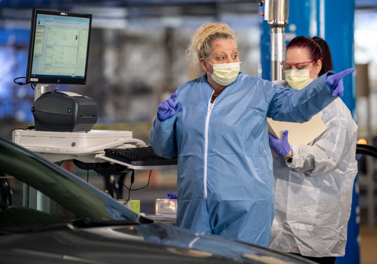 Clinical staff workers conduct a drive-through COVID-19 test Wednesday, March 18, 2020, at Allegheny Health Network's Wexford Health + Wellness Pavilion in Wexford, Pa. (Steph Chambers/Pittsburgh Post-Gazette via AP Photo)