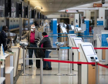 Passengers wearing face masks check in at Philadelphia International Airport in Philadelphia, Thursday, March 19, 2020. (Matt Rourke/AP Photo)