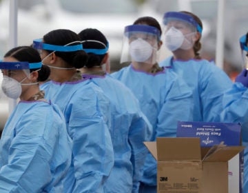 Medical staff prepare to start working at a drive-through testing center for COVID-19 in Paramus, N.J., on Friday, March 20, 2020. (AP Photo/Seth Wenig)