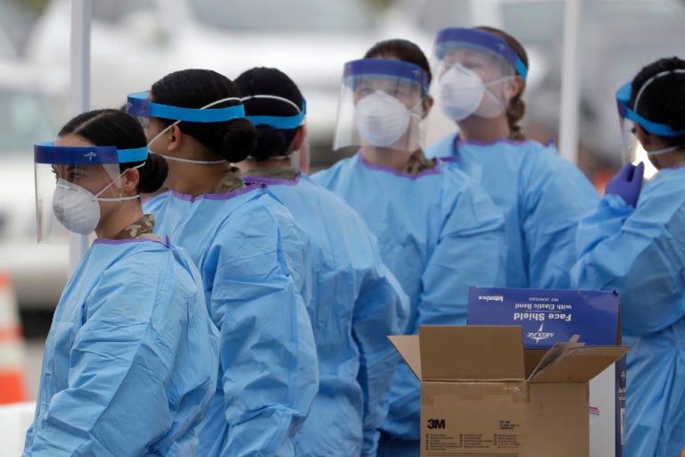 Medical staff prepare to start working at a drive-through testing center for COVID-19 in Paramus, N.J., on Friday, March 20, 2020. (AP Photo/Seth Wenig)