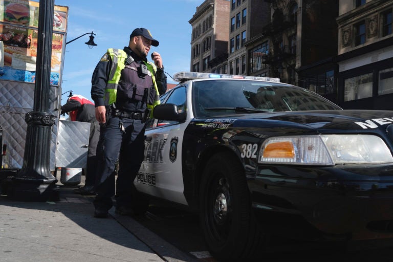 A Newark police officer uses his car megaphone to encourage social distancing at an intersection in Newark, N.J., Thursday, March 26, 2020. (AP Photo/Seth Wenig)