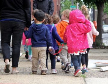 A group of children walk with their caregivers on Vine Street. (Emma Lee/WHYY)