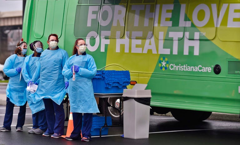 Nurses stand at a COVID testing area