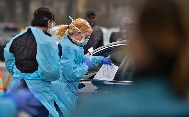 A nurse with ChristianaCare gives a free test for the coronavirus to a driver in Delaware. (Butch Comegys for WHYY)