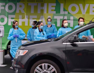 Nurses with ChristianaCare wait for the next vehicle to arrive to test people for the coronavirus on Friday, March 13, 2020, at the Riverfront complex in downtown Wilmington, Del. (Butch Comegys for WHYY)