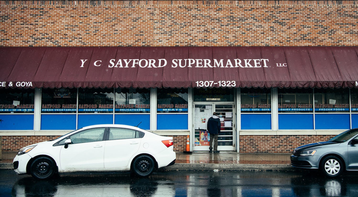 At the Sayford Market in Harrisburg, an employee tells a customer through the glass that they’re closed for the day. (Dani Fresh for Keystone Crossroads)