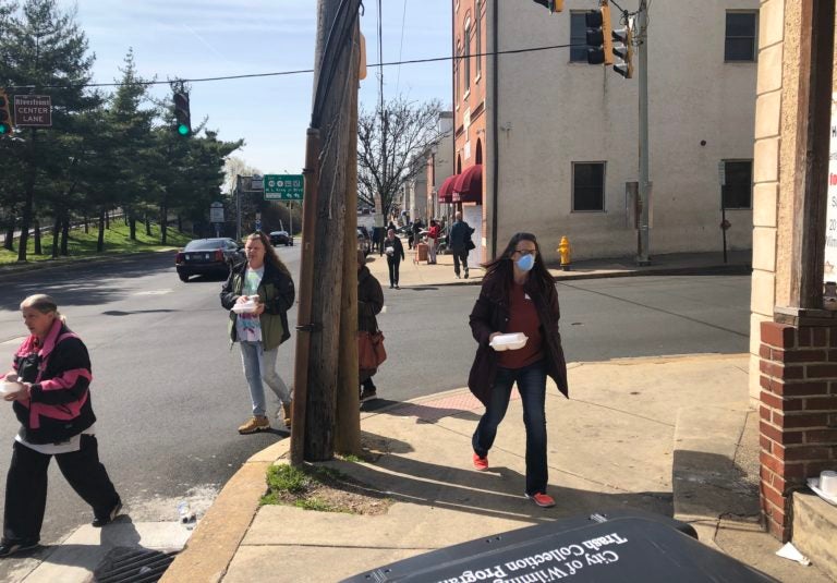 People usually eat inside at the Emmanuel Dining Room but the coronavirus crisis has forced them to disperse after getting their meal at the door.  (Cris Barrish/WHYY)