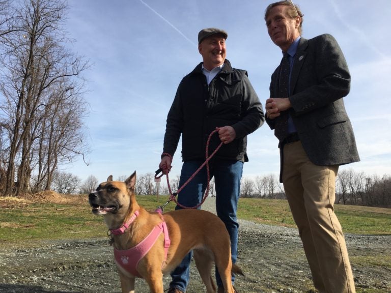 State Sen. Jack Walsh (left) holds his dog Maisey as he talks with State Rep. Mike Ramone at the Carousel Park Bark Park Wednesday morning. Both lawmakers sponsored a bill extending protections for dogs being kept outside. (Mark Eichmann/WHYY)