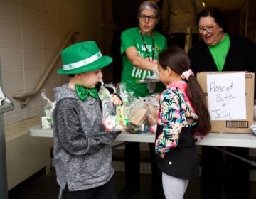 Gavin Holloman, 7, and Taylor Blake choose lunch and breakfast meals at the Bancroft School amid school shutdowns. (Kimberly Paynter/WHYY) 