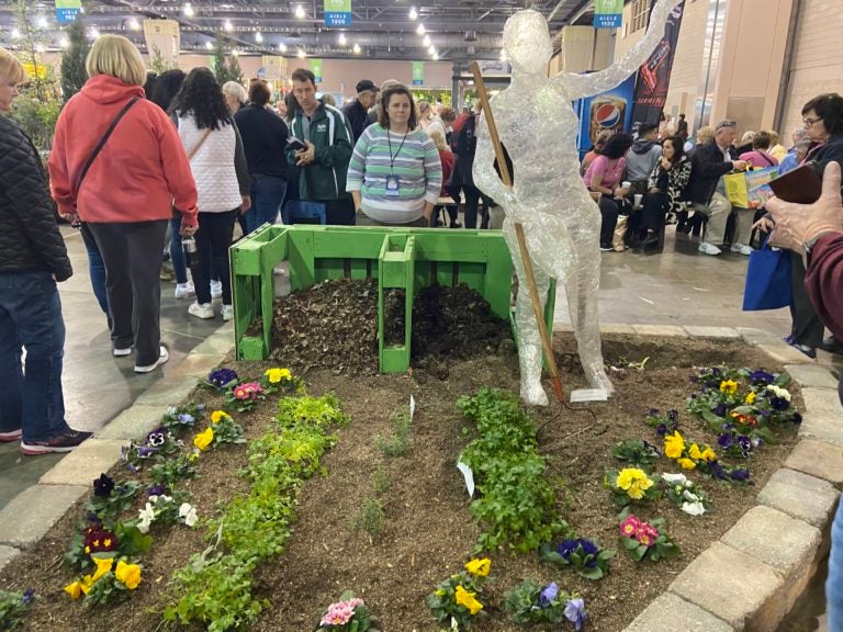 Teacher Nora Melley in front of the Lincoln High School exhibit at the Philadelphia Flower Show. (The Notebook)