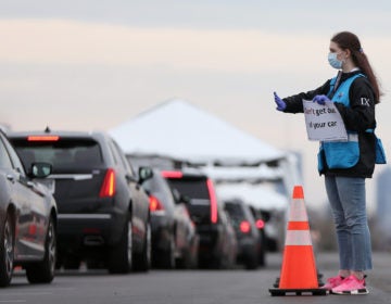 Philadelphia Medical Reserve Corps volunteer Emma Ewing, a sophomore at Temple University, directs cars at the city's coronavirus testing site next to Citizens Bank Park in South Philadelphia on Friday, March 20, 2020. (Tim Tai/The Philadelphia Inquirer)