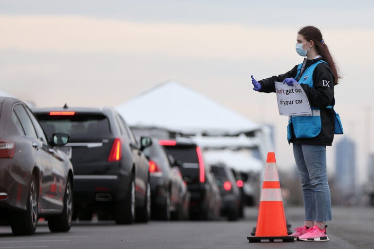 Philadelphia Medical Reserve Corps volunteer Emma Ewing, a sophomore at Temple University, directs cars at the city's coronavirus testing site next to Citizens Bank Park in South Philadelphia on Friday, March 20, 2020. (Tim Tai/The Philadelphia Inquirer)