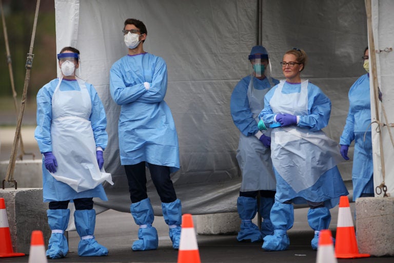 Medical workers wait for cars to pull up to the swabbing tent at the city's coronavirus testing site next to Citizens Bank Park in South Philadelphia on Friday, March 20, 2020. (The Philadelphia Inquirer)