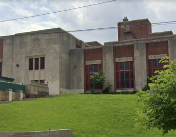 Philadelphia's Central High School is visible, a red-brick building sitting on top of a green hill.