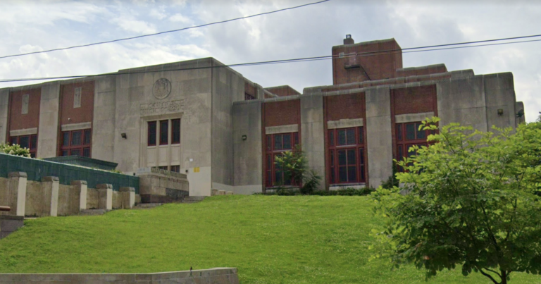 Philadelphia's Central High School is visible, a red-brick building sitting on top of a green hill.