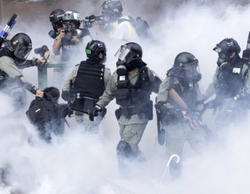 Police in riot gear move through a cloud of smoke as they detain a protester, in November. Freedom House cited the willingness of people in Hong Kong to protest as encouraging. (Ng Han Guan/AP Photo)