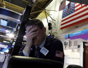 A trader reacts on the floor of the New York Stock Exchange on Monday. Major U.S. stock indexes plunged 7% before trading was temporarily halted. (Richard Drew/AP)