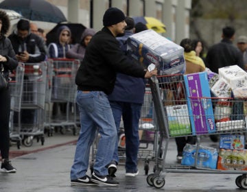 Costco customers roll groceries to their cars as others wait to enter the store on March 14 in San Leandro, Calif. (Ben Margot/AP Photo)