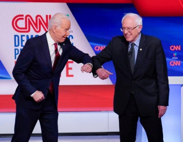 Former Vice President Joe Biden, left, and Sen. Bernie Sanders, I-Vt., right, greet one another before they participate in a Democratic presidential primary debate at CNN Studios in Washington, Sunday, March 15, 2020. (AP Photo/Evan Vucci)