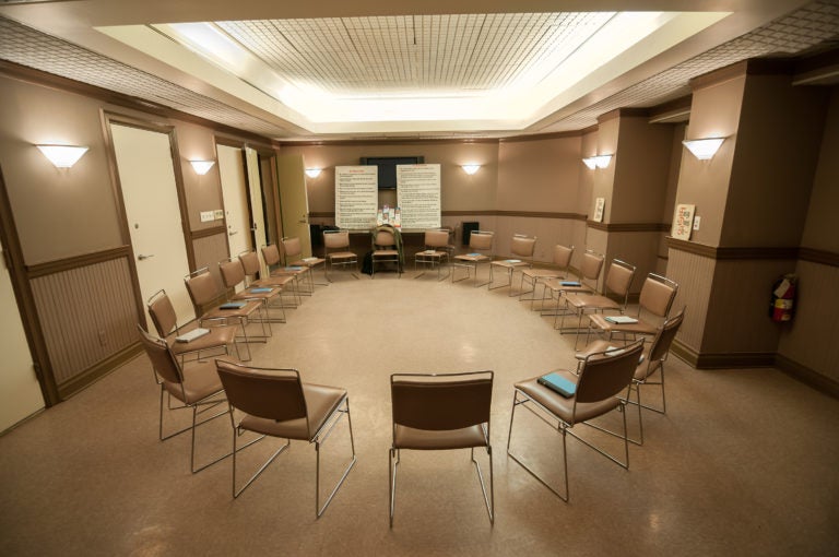 12 step recovery meeting room with chairs and signs. (Bigstock/blueskies9)