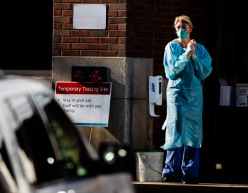 A health care worker stands by at a COVID-19 temporary testing site at Abington Hospital in Abington, Pa., Wednesday, March 18, 2020. (Matt Rourke/AP Photo)