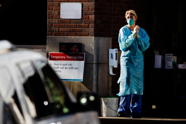 A health care worker stands by at a COVID-19 temporary testing site at Abington Hospital in Abington, Pa., Wednesday, March 18, 2020. (Matt Rourke/AP Photo)