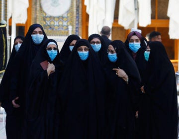 With the coronavirus spreading in dozens of countries, the World Health Organization officially declared the COVID-19 viral disease a pandemic Wednesday. Here, Muslim women wear protective face masks at the Imam Ali Shrine following an outbreak of the coronavirus in the city of Najaf, Iraq. (Alaa Al-Marjani/Reuters)