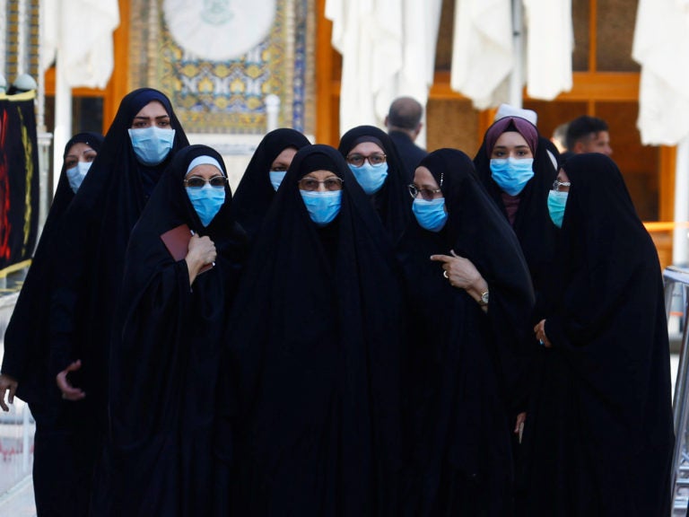 With the coronavirus spreading in dozens of countries, the World Health Organization officially declared the COVID-19 viral disease a pandemic Wednesday. Here, Muslim women wear protective face masks at the Imam Ali Shrine following an outbreak of the coronavirus in the city of Najaf, Iraq. (Alaa Al-Marjani/Reuters)