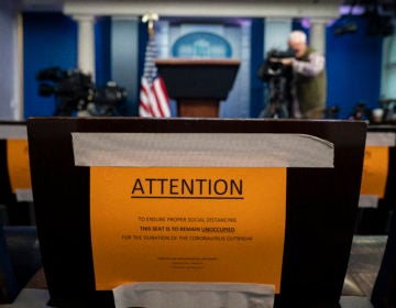 Signs in the briefing room of the White House indicate social distancing measures being taken to separate reporters working at the White House, Monday, March 16, 2020, in Washington. (AP Photo/Evan Vucci)