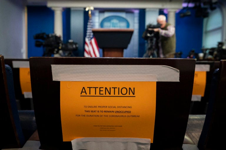 Signs in the briefing room of the White House indicate social distancing measures being taken to separate reporters working at the White House, Monday, March 16, 2020, in Washington. (AP Photo/Evan Vucci)