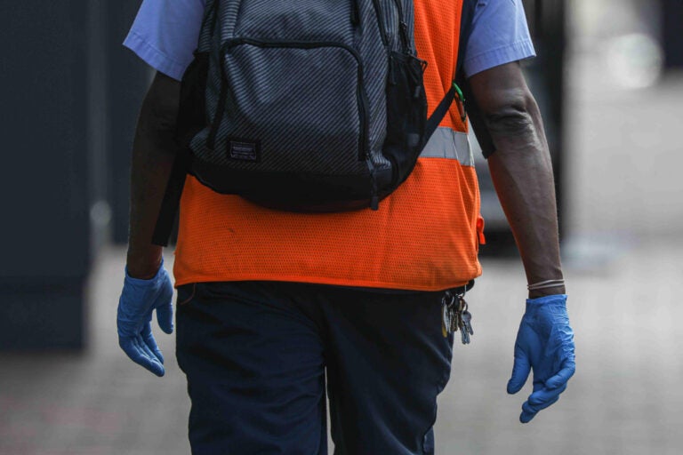 A man walks on Market Street in Wilmington, Del. wearing protective gloves on Friday, March 27, 2020. (Saquan Stimpson for WHYY)